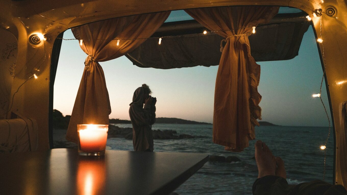 person lying on couch with body of water view at dusk